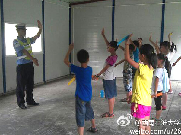 7月24日,西南石油大學校報記者團赴雅安支教志愿隊給孩子們帶來了一堂不一樣的職業體驗課,其中包括了醫生,老師,警察,科學家,飲料師五種職業。隊員們希望,孩子們在各個職業老師指導下,能對未來懷有理想充滿希望。圖為“交警”正在教導孩子們交通指揮的基礎手勢。