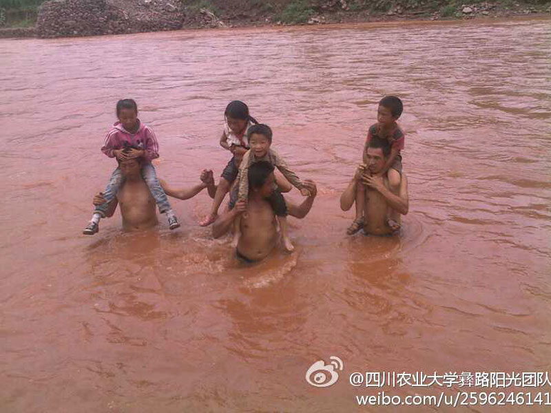 7月17日,四川農業大學“彝路陽光”團隊來到西昌涼山州喜德縣兩河口鎮開展支教活動。兩河口鎮地處偏僻,全村的孩子每天都要步行兩個多小時上學,途中需要淌過一條30米寬的河流。圖為村民們馱著孩子渡過齊腰深的河流。