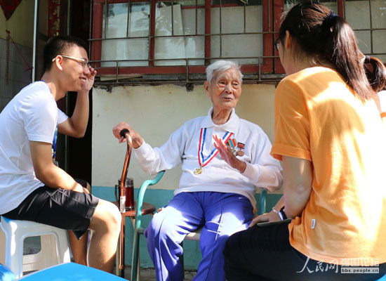 志愿者與抗戰(zhàn)老兵麥成坤(中)。