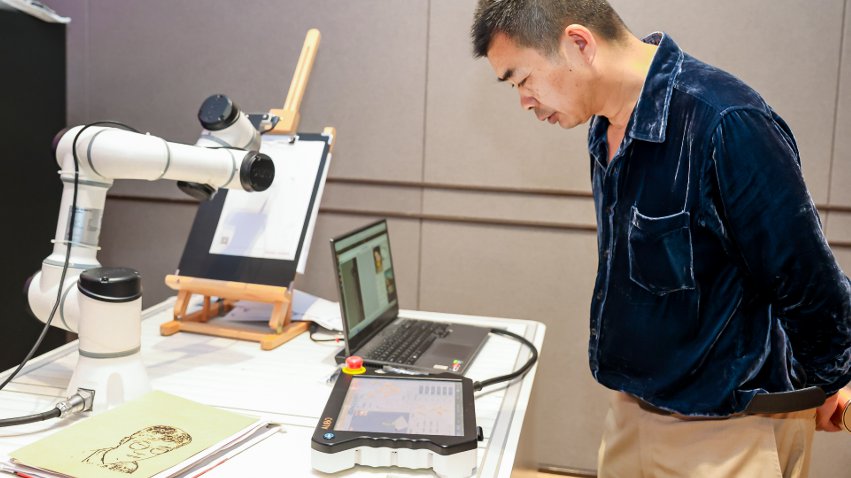 嘉賓體驗遨博AI繪畫機器人。主辦方供圖